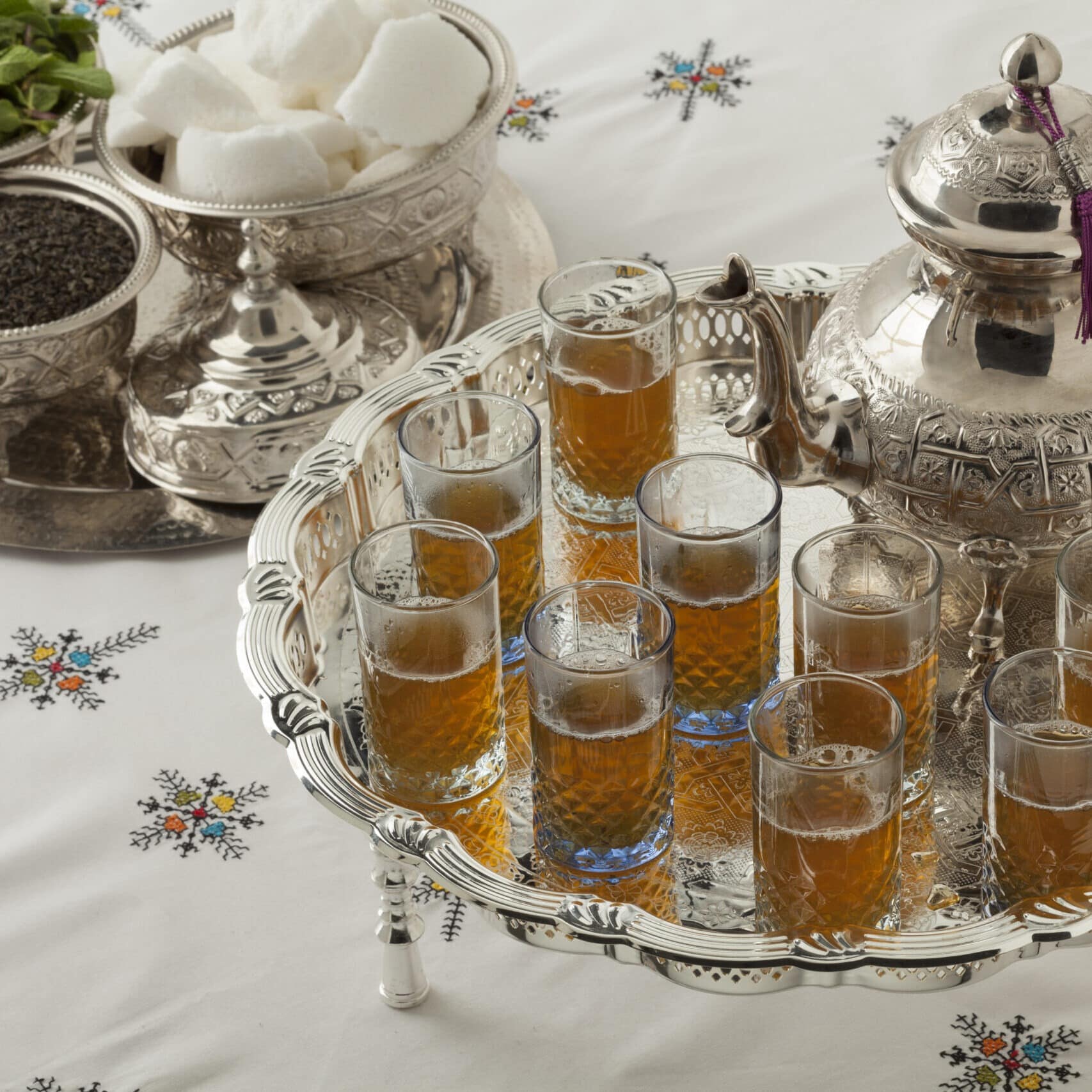 Traditional festive Moroccan silver tea set and glasses on the table close up